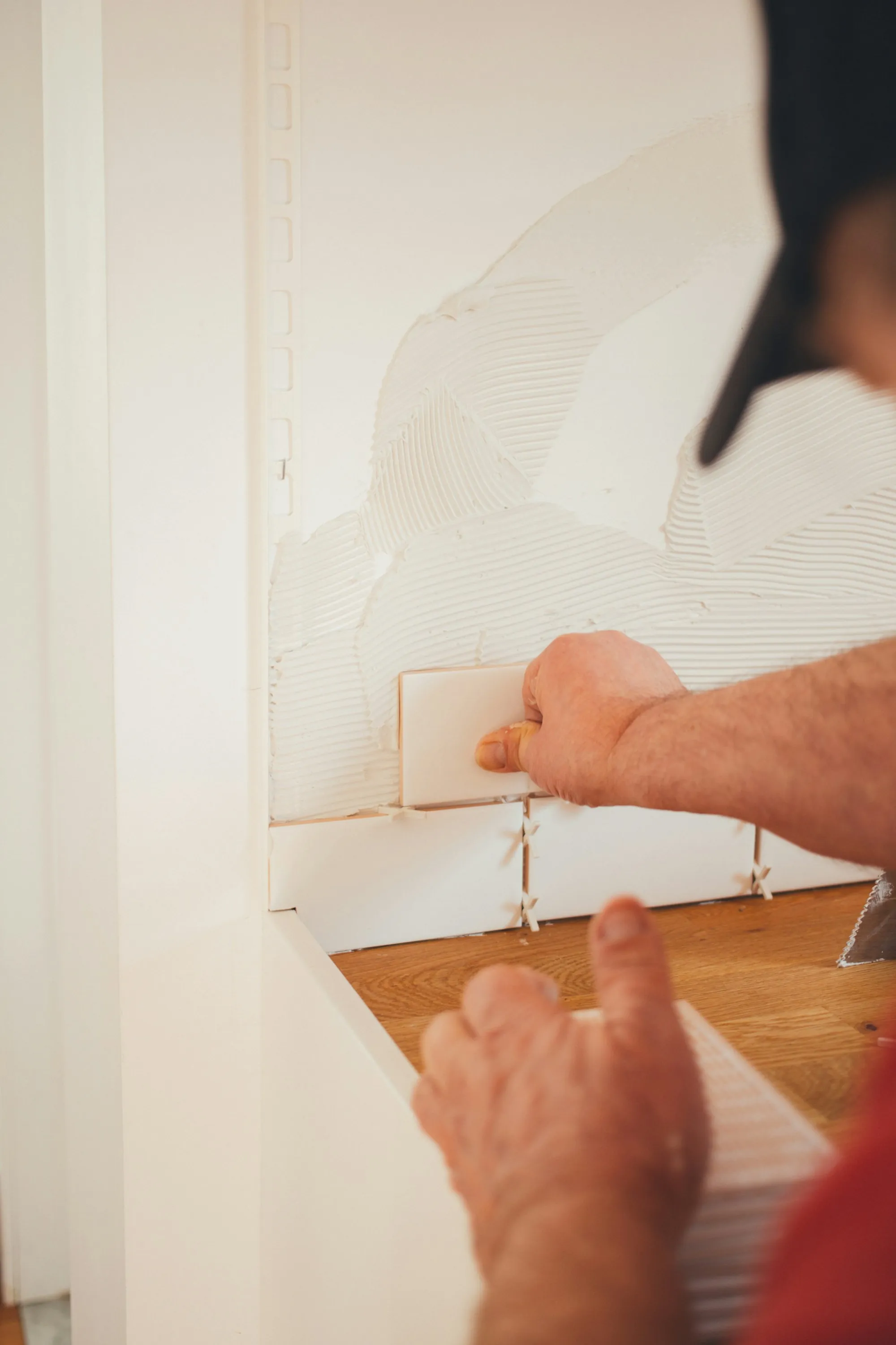 Installer setting wall tile during a remodel