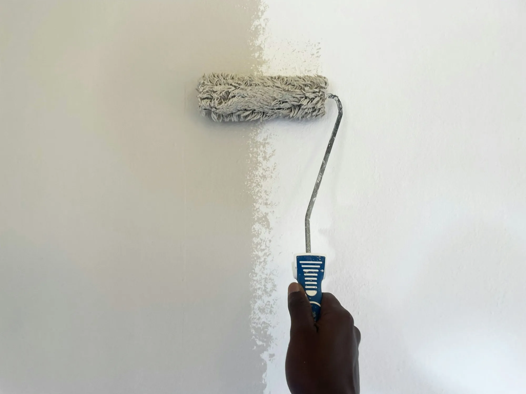 Paint roller applying a fresh coat to an interior wall